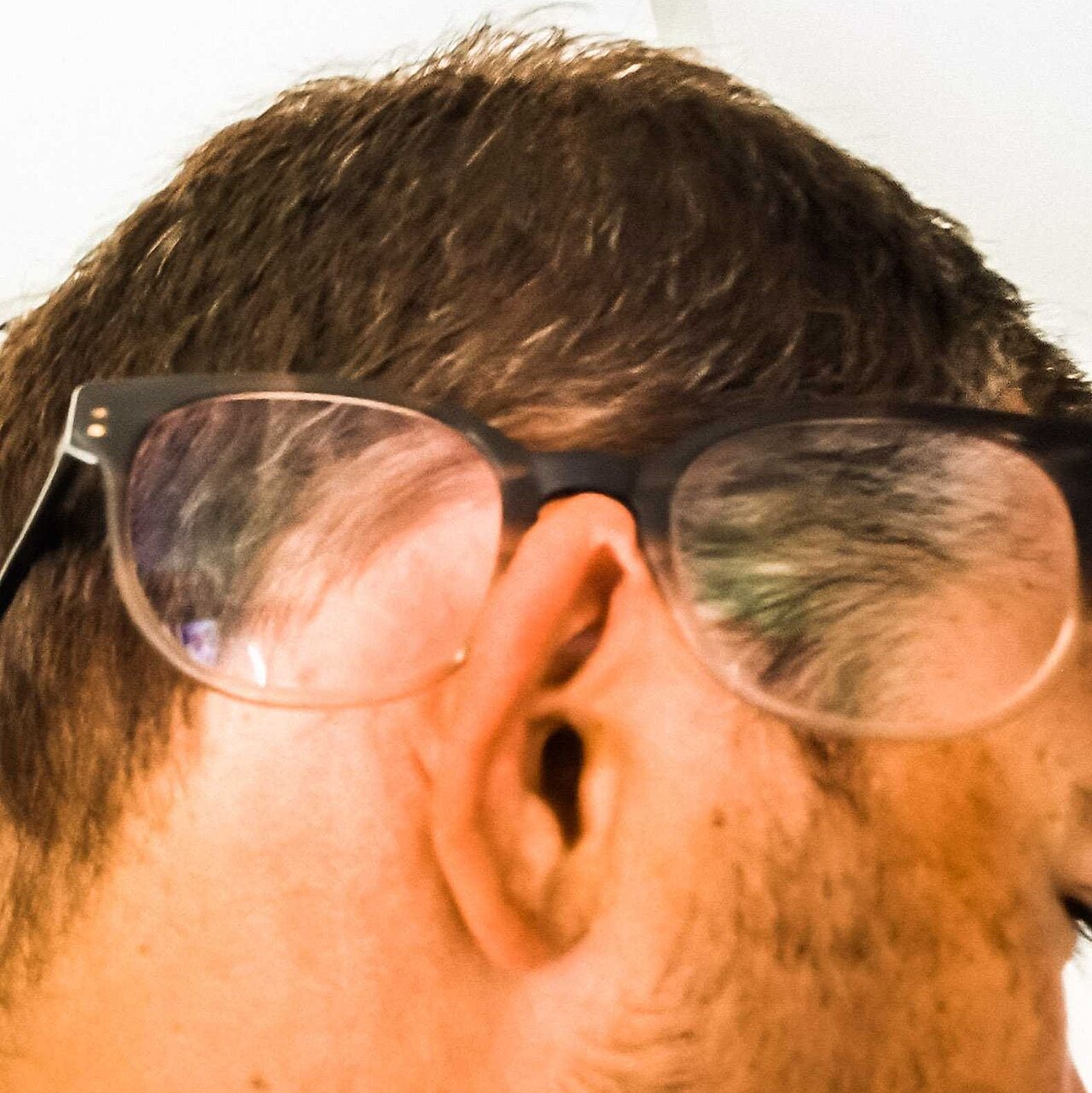 Profil eines Mannes und auf seinem Ohr sitzt eine Brille