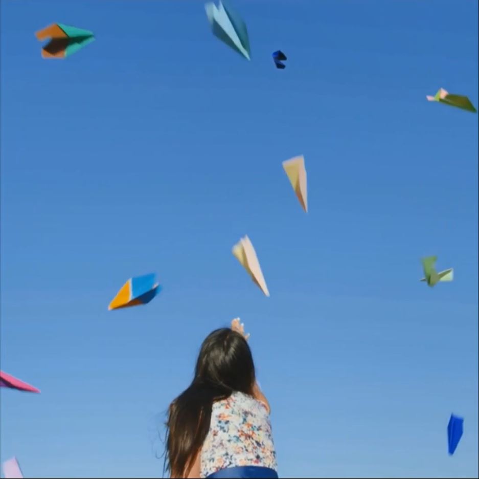 Frau wirft Papierflieger in die Luft