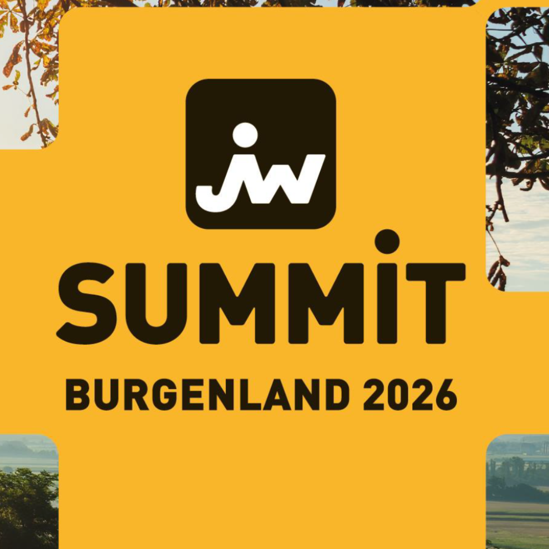 Ein Foto vom Burgenland, zu sehen sind ein paar Hügel und Bäume. Im Vordergrund wird das Bild aber von einer großen gelben Fläche verdeckt auf der in schwarz "Summit Burgenland 2026" steht und das Logo des JW Summit ist darauf abgebildet.