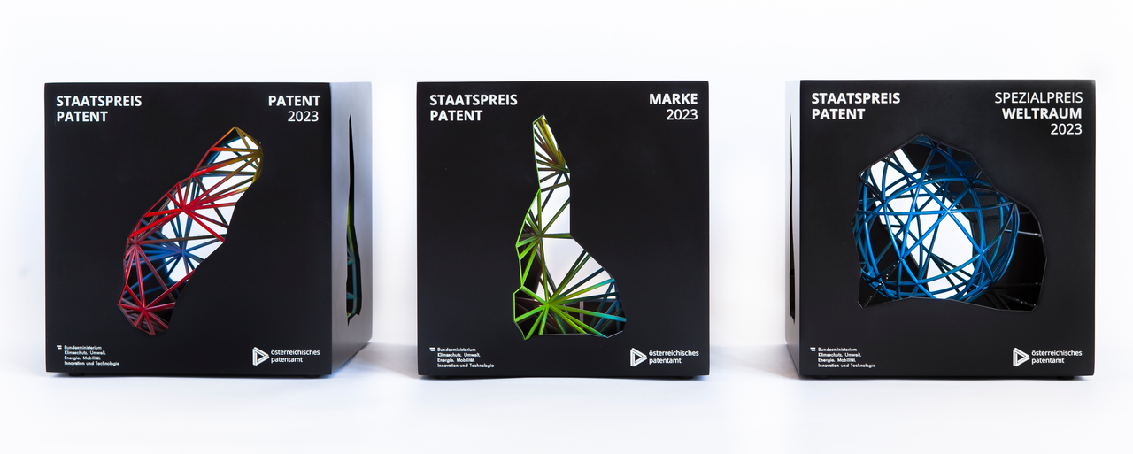 Fotos der 3 Staatspreis Patent Trophäen. Es sind 3 schwarze Metallwürfel mit unterschiedlichen Geflechten im Innenleben.