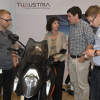 am Bild die Präsidentin des Österreichischen Patentamtes mit Teilnehmern des Innovationsmarathons in Alpbach rund um ein modernes Motorrad