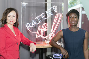 Fotografie Patentamtspräsidentin Mariana Karepova und Erfinderin Charlotte Ohonin vor einem Neon Schild mit der Aufschrift "Patent it!"