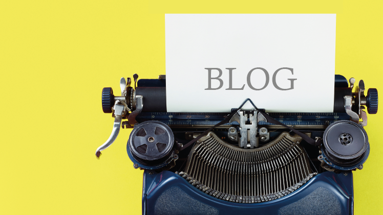 Eine Schreibmaschine mit Zettel darin auf dem "BLOG" geschrieben steht auf gelben Hintergrund.