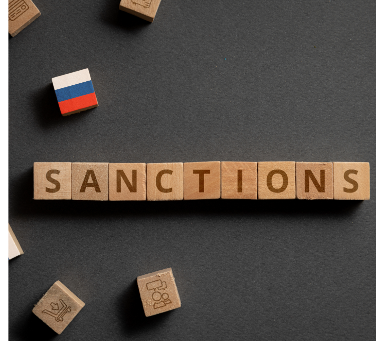 Das Wort Sanctions geschrieben mit Holzbuchstaben und eine russische Fahne aus Holzbausteinen.